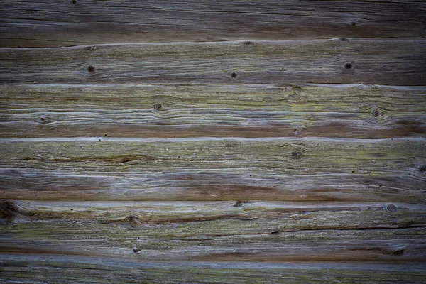 Holzstämme eines alten Hauses. Nahaufnahme. Verwitterte natürliche graue Holzstruktur. Hintergrund. Horizontales Foto — Stockfoto