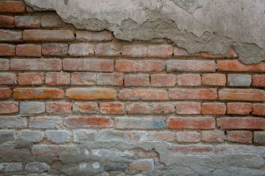 Eski, eski tuğla duvar dokusunun kırmızı arkaplanı. Alçı ve duvar harcı izleri olan eski bir taş duvarın yakın görüntüsü..