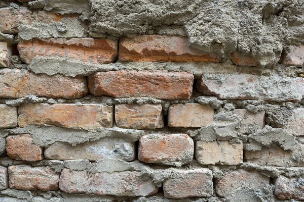 Red background of old vintage brick wall texture. Close-up view of an old stone brick wall with traces of plaster and masonry mortar. — Stock Photo, Image