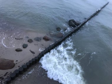 Baltık Denizi kıyısındaki ahşap bir dalgada dalgalar kırılıyor..