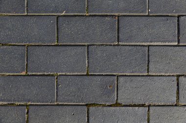 Clinker bricks on the pavement. Stone roads made of dark gray bricks. 