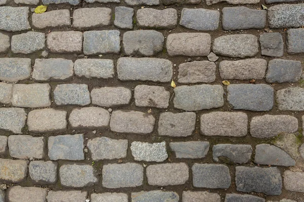 Paving stones from granite. The stones are gray and red. Old stone roads. — Stock Photo, Image