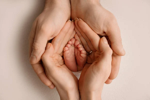 Le palme del padre, la madre stanno tenendo il piede del neonato in una coperta bianca. Piedi del neonato sui palmi dei genitori. Studio macro foto di un bambino dita dei piedi, tacchi e piedi. — Foto Stock