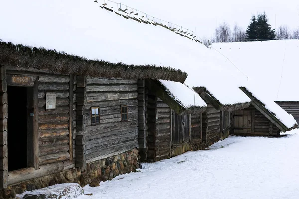 Une vieille cabane en bois, une maison en rondins avec un toit de chaume. Maison en rondins avec grange. — Photo