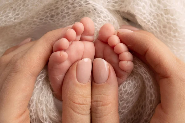 Mother is doing massage on her baby foot. Closeup baby feet in mother hands. Prevention of flat feet, development, muscle tone, dysplasia. Family, love, care, and health concepts. Studio macro. — Stock Photo, Image