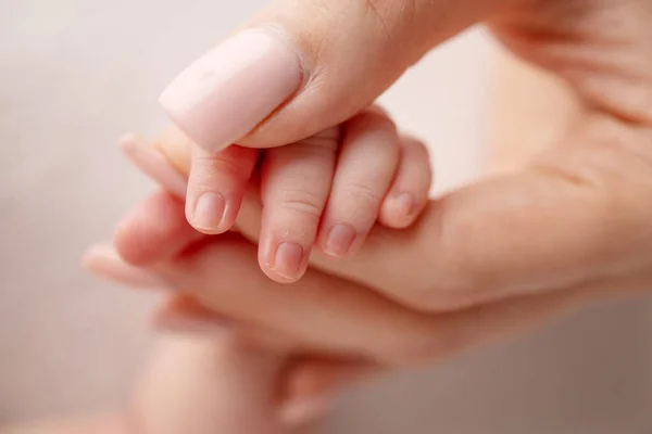 The hand of a newborn in the mothers hand. Mom and her child. Happy family concept. Beautiful concept image of motherhood.