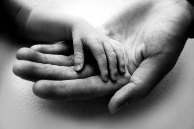The hand of a newborn in the mothers hand. Mom and her child. Happy family concept. Beautiful concept image of motherhood.
