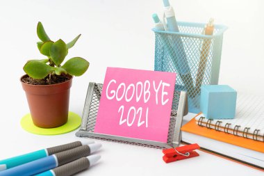 Kavramsal gösteri Elveda 2021. Ayrılırken veya geçen yılın sonunda Düzenli Çalışma Alanı Kurulumu Masa Aletleri ve Ekipmanları Not Alırken iyi dilekleri dile getirmek için kelime