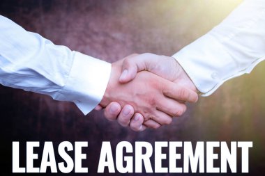 Kira sözleşmesini sunan metin başlığı. Kontratta tek bir parti için yazılan sözcüğe göre iki profesyonel iyi giyimli iş adamı kapalı mekanda el sıkışıyor.