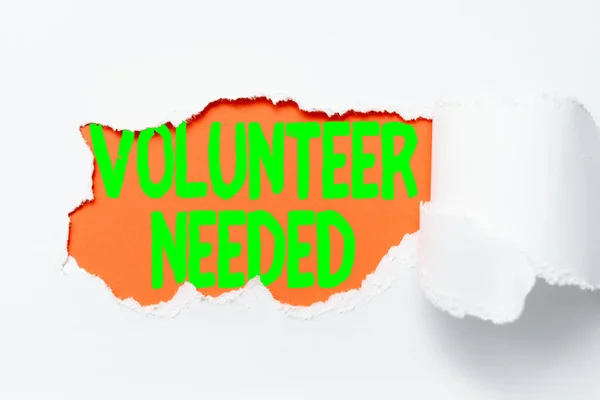 Handwriting text Volunteer Needed. Business approach Looking for helper to do task without pay or compensation Tear on sheet reveals background behind the front side