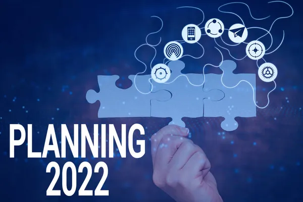 Teksten weergeven Planning 2022. Word Written on process of making plans for something next year Hand Holding Jigsaw Puzzle Piece Unlocking New Futuristic Technologies. — Stockfoto