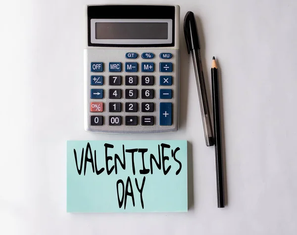 Légende conceptuelle Saint Valentin S Day. Temps d'approche d'affaires lorsque vous montrez des sentiments d'amour et d'affection Carnet spirale ouvert blanc avec une calculatrice et un stylo sur la table. — Photo