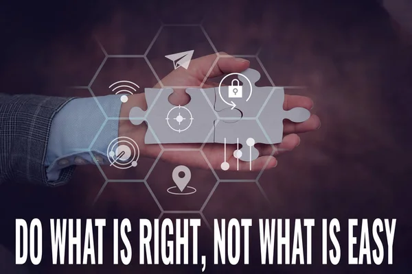 Conceptual caption Do What Is Right Not What Is Easy. Internet Concept willing to stand up for what is right Hand Holding Jigsaw Puzzle Piece Unlocking New Futuristic Technologies.