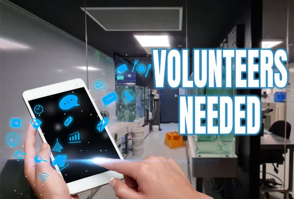 Hand writing sign Volunteers Needed. Concept meaning need work or help for organization without being paid Woman Suit Writing On Screen Holding Tablet Showing Futuristic Technology.