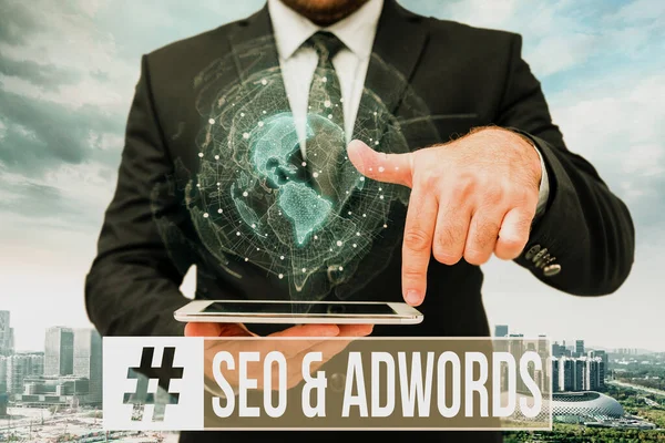 Leyenda conceptual Seo y Adwords. Concepto de negocio: son las principales herramientas componentes de Search Engine Marketing Man In Uniform Standing Holding Tablet Typing Futuristic Technologies. —  Fotos de Stock