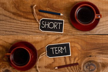 Kısa Dönem 'i gösteren bir işaret. Boş Etiket Etiketlerinin Bilgi Etiketi İşareti ile Bağlı olduğu nispeten kısa bir zaman diliminde meydana gelmesi veya dahil edilmesi için sözcük