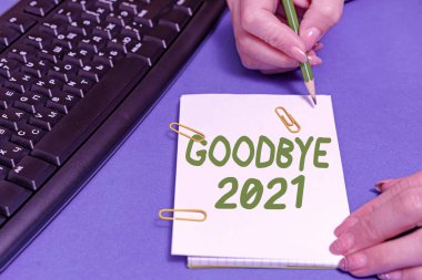 Elveda 2021 metni yazılıyor. Ayrılırken veya geçen yılın sonunda iyi dilekleri ifade etmek için sözcük. Eller bilgisayarın klavyesine basar ve yeni fikirleri yazar..