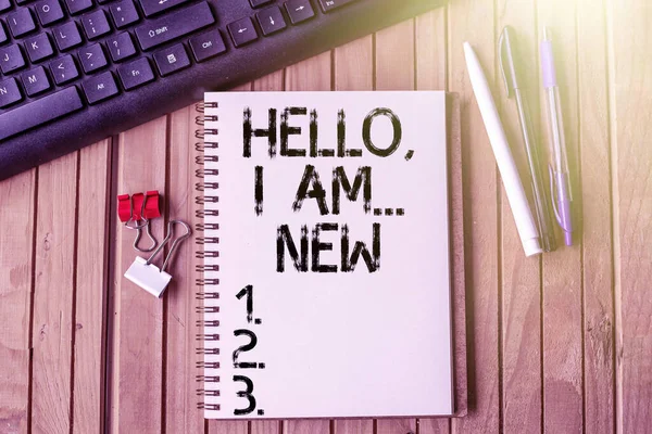 Sinal de escrita de mão Hello I Am New. Conceito de Internet usado saudação ou começar a conversa telefônica vazio aberto recortado diário ao lado canetas de teclado em cima da mesa de madeira. — Fotografia de Stock