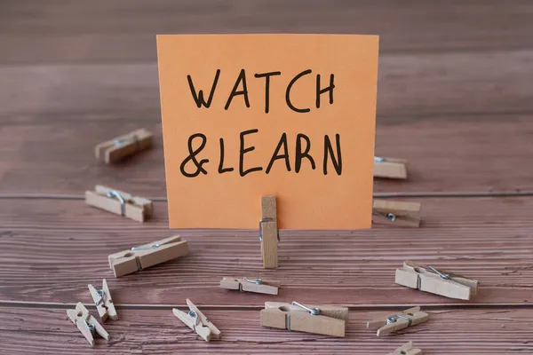 Text sign showing Watch And Learn. Concept meaning demonstrating an action or ideas of how to do things Blank Square Note Surrounded By Laundry Clips Showing New Meaning. — Stock Photo, Image