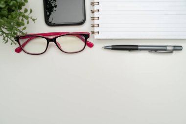 Ofis malzemeleri klavye, bardaklar ve uzaktan çalışma için kahve fincanı, sıcak içecek ve gözlüklerle çalışmak için çeşitli okul gereçleri..