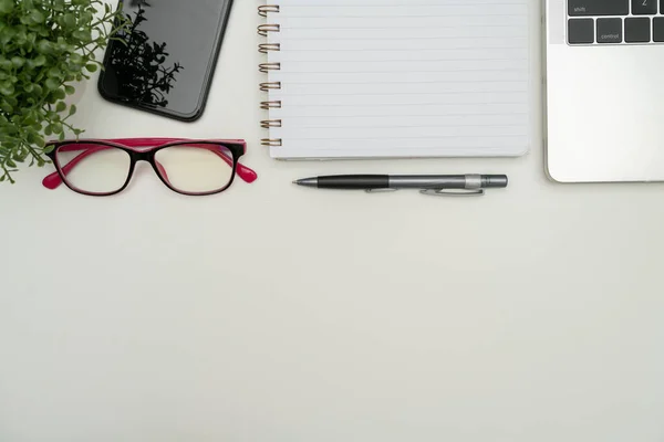 Irodai kellékek íróasztal felett billentyűzet és szemüveg és kávé kupa távolról történő munkavégzéshez, válogatott iskolai segédprogramok forró itallal és szemüveggel való tanuláshoz. — Stock Fotó