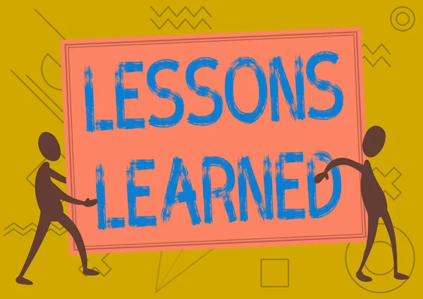 Señal de escritura a mano Lecciones aprendidas. Palabra de experiencias proyecto destilado que debe tomar activamente Dos colegas de pie llevando gran tablero en blanco que muestra la unidad. —  Fotos de Stock