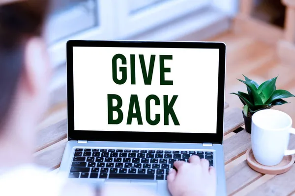 Inspiration visar tecken Give Back. Business visa upp handlingen att ge någon något som de ägde eller hade innan Kvinna skriva på laptop bredvid Coffe Mug och växt som arbetar hemifrån. — Stockfoto