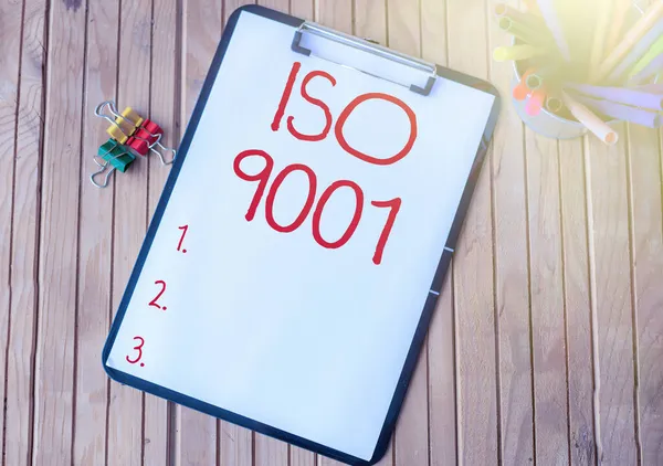 Writing displaying text Iso 9001. Word for designed help organizations to ensure meet the needs of customers Plain Office Clipboard With Stacks Of Pens In A Holder Placed On A Table. — Stock Photo, Image