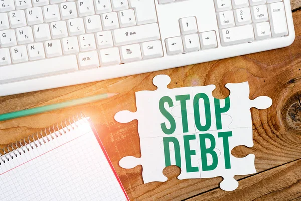 Text sign showing Stop Debt. Concept meaning does not owning any money or things to any individual or companies Building An Unfinished White Jigsaw Pattern Puzzle With Missing Last Piece — Stock Photo, Image
