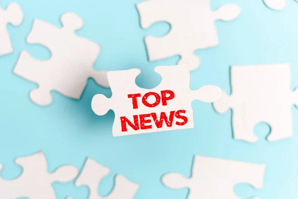 Teken met Top News. Word Written on information that is being received and broadcast about a event Building An Unfinished White Jigsaw Pattern Puzzle With Missing Last Piece — Stockfoto