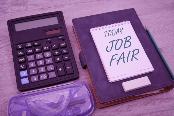 Bildunterschrift: Jobmesse. Business-Schaufenster-Veranstaltung, bei der Arbeitgeber Personalvermittler Informationen an Mitarbeiter weitergeben Leere Notizbuchseite mit Taschenrechner und geometrischer Schreibwaren über Tisch. — Stockfoto