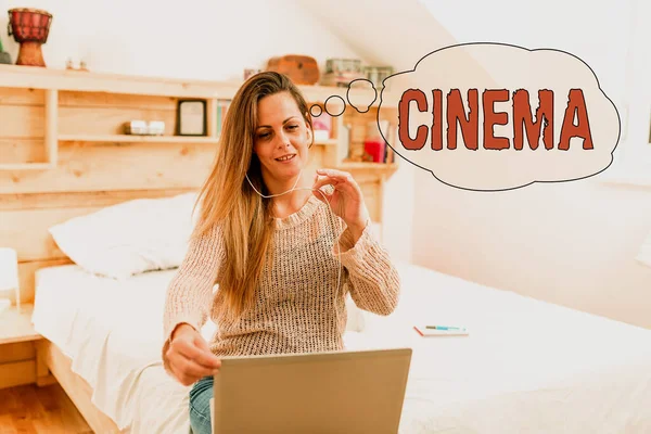 Sinal de escrita à mão Cinema. Teatro de abordagem de negócios onde os filmes são exibidos para entretenimento público Cinema Mulher vediocalling através do laptop do quarto com fones de ouvido com fio — Fotografia de Stock