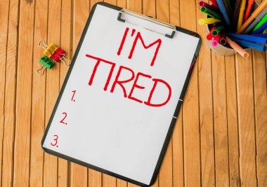 El yazısı tabelası Yorgunum. Tükenmiş güç ve enerji üzerine yazılmış sözcük Yorgunluktan bitkin düşmüş Ofis Panosu Bir Holder 'a yerleştirilmiş kalemlerle dolu.