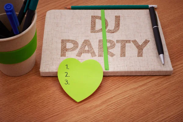 Signo de texto que muestra Dj Party. Concepto que significa persona que introduce y reproduce música popular grabada en la radio lisa Cuadernos abiertos en blanco con pila de plumas Contenedor sobre la mesa. — Foto de Stock