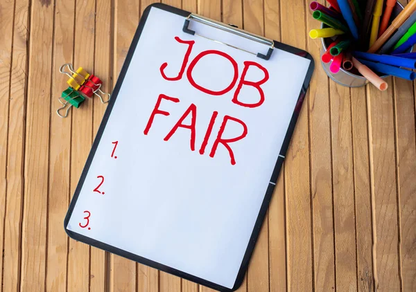 Firma mostrando la Feria del Trabajo. Palabra para evento en el que los empleadores reclutadores dan información a los empleados Portapapeles de oficina llano con pilas de plumas en un titular colocado en una mesa. —  Fotos de Stock