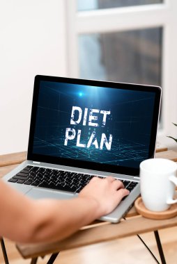 Kavramsal Diyet Planı. İş fikri, sağlıklı beslenme alışkanlığı edinmek ya da gerçekleştirmek için detaylı bir teklif sunuyor. El Bilgisayarda, Masanın Üzerinde, Evden Çalışan Bardakta..