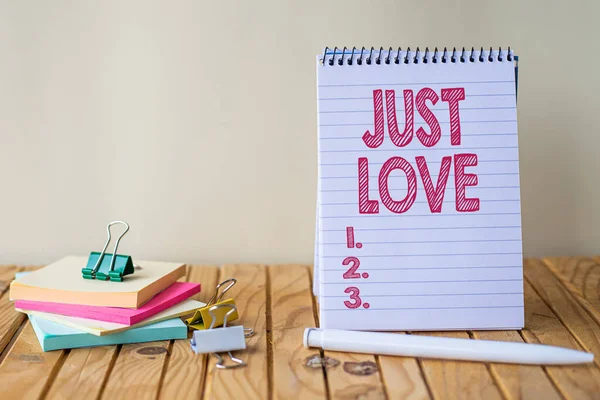 Kézírás szöveg Just Love. Üzleti áttekintés, hogy fizikailag érdeklődik valaki iránt Egy érzelmi kötődés Üres spirál jegyzettömb tollal a ragacsos jegyzetek mellett. — Stock Fotó