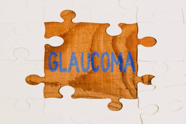 Glaucoma metni gösteriliyor. Anlamı, görme sinirlerinde hasara yol açan göz hastalıkları. Eksik kalan son parçayla tamamlanmamış beyaz testere deseni bulmacası.