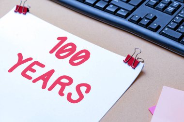 100 Yılı gösteren bir tabela. 100 yıllık özel bir günü hatırlamak için kavramsal fotoğraf. Çeşitli Koleksiyon Ofisi Kırtasiyesi Fotoğrafı Tablonun Üzerine yerleştirildi