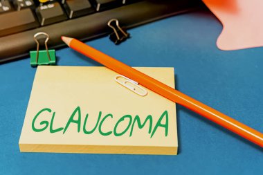 Glaucoma metni gösteriliyor. Optik sinirsel görme kaybına yol açan kavramsal fotoğraf göz hastalıkları. Masanın üzerine yerleştirilmiş çok çeşitli koleksiyon ofisi kırtasiyesi.