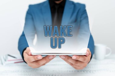 El yazısı: Uyan. Kelime, uyanan ya da uyandırılan bir kişinin haberleşme teknolojisi, akıllı telefon ve video çağrısını sunması üzerine yazılmış.