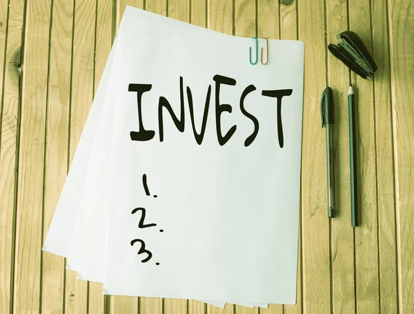 Tekst pokazujący inspirację Invest. Biznes showcase komercyjne przedsięwzięcie z oczekiwaniem osiągnięcia zysku biurowy papier firmowy przycięte razem układanie płasko na stole. — Zdjęcie stockowe