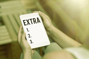 Ekstra gösteren bir tabela. Varolan ya da olağan sayıya eklenen iş gösterimi, normalin yanı sıra İnsanları Birleştiren Ses ve Görüntü Yetenekleri Verin