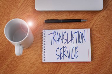 Metin Çevirisi Servisi gösteriliyor. Ana Dil Kapalı Laptop 'tan Eşdeğer Hedef Dili için sözcük Kalem ve kahve fincanı ile Boş Günlük Masanın Üzerinde.