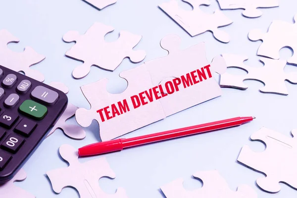Text showing inspiration Team Development. Internet Concept learn why and how small groups change over time with graphs Building An Unfinished White Jigsaw Pattern Puzzle With Missing Last Piece — Stock Photo, Image