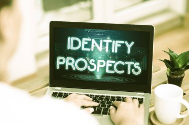 El yazısı işareti Prospects 'u Tanımlayın. İnternet Konsepti Muhtemel müşteri ideali Müstakbel Bağışçı Kadın Laptop 'ta kahve fincanı ve fabrikanın yanında ev işi yapmakla meşgul.