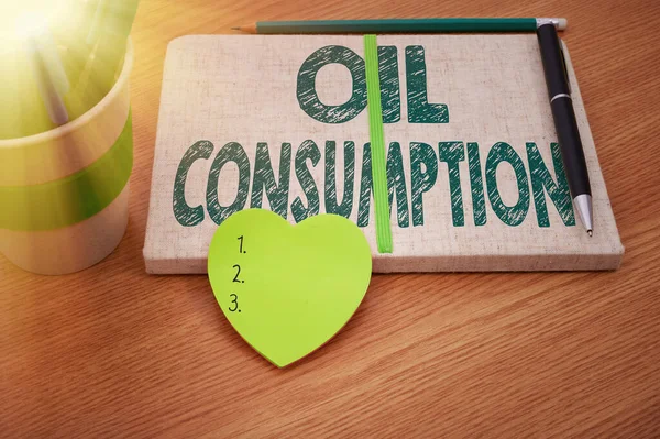 Inspiration showing sign Oil Consumption. Word for This entry is the total oil consumed in barrels per day Plain Blank Open Notebooks With Stack Of Pens Container Over Table. — Stock Photo, Image