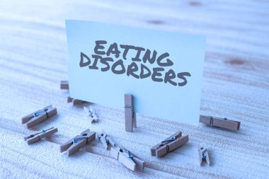 Kavramsal Başlık Yeme Bozuklukları. Yeni Anlamı Gösteren Çamaşır Klipleri ile çevrili Boş Meydan Nota Psikolojik anormal yemek alışkanlıkları üzerine yazılmış herhangi bir kelime.