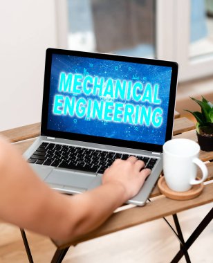 Kavramsal ekran Makine Mühendisliği. Tasarım İmalat Kullanımı ile ilgili kavramsal fotoğraf anlaşmaları Makine Kullanımı Laptop 'ta kahve fincanı ve fabrikanın yanında ev işi yapmakla meşgul.