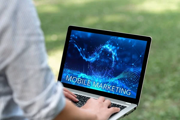 Text som visar inspiration Mobile Marketing. Affärsöversikt teknik fokuserade nå publiken på sin smarta enhet Kvinna skriva på bärbar dator i parken ensam utför fjärrjobb. — Stockfoto